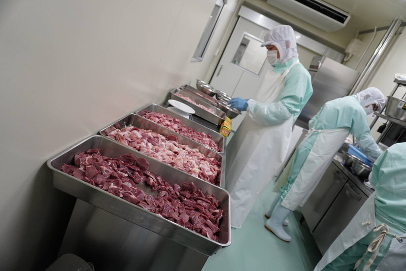 衛生管理された工場で肉を仕込む様子