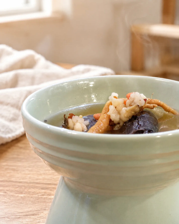 緑の器に盛った烏骨鶏の参鶏湯